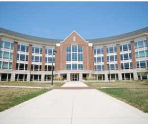 Modern educational institute building with glass windows and brick architecture under a clear blue sky