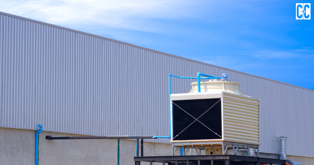 “Industrial cooling unit with blue pipes beside a metal-clad building.